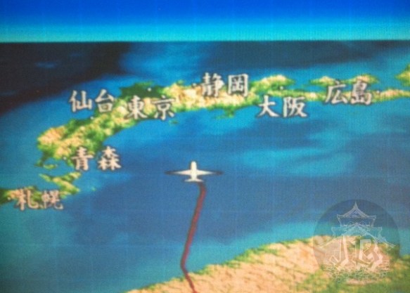 The screen at the seat showing the plane over the sea of Japan, from behind of sorts