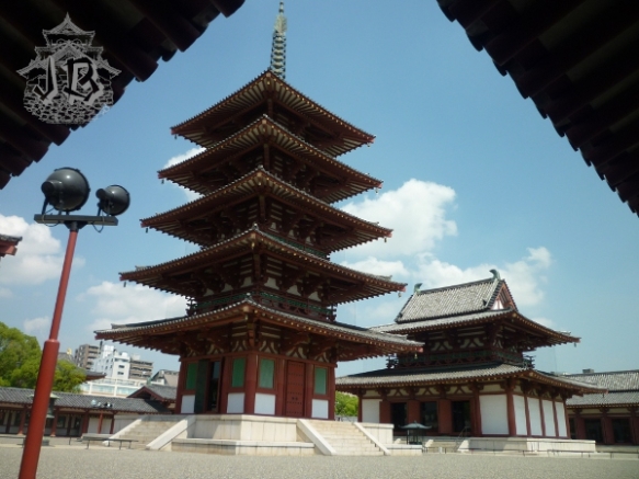 A five-story pagoda and a temple building. They are both dark red and white, with some green and golden decoration
