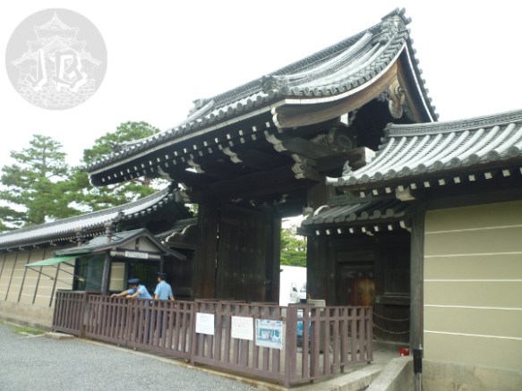 The entrance to the Imperial palace - a gate through the walls. Two police officers in blue are chatting at the fence