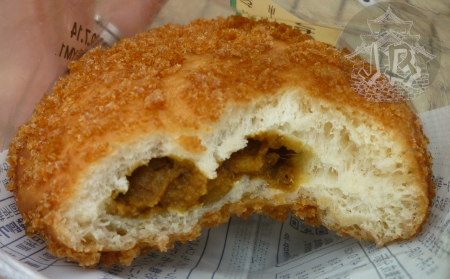 A breaded bun, open. The inside is white, with a golden filling in the middle