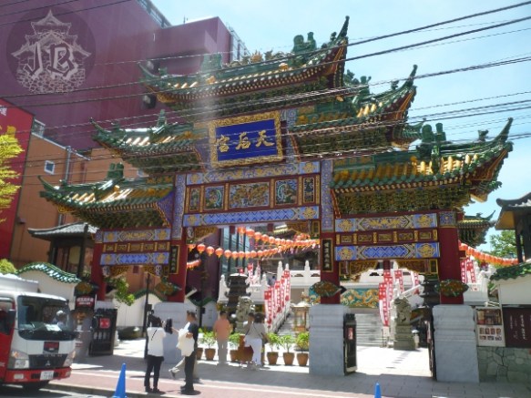 An ellaborate temple entrance, with lots of peaks and lanterns behind it