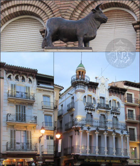 Plaza del Torico: a little bull standing on top of a column. Behind it stand two Modernist Houses at dusk