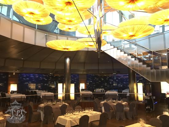 An empty restaurant surrounded by an aquarium where fish swim