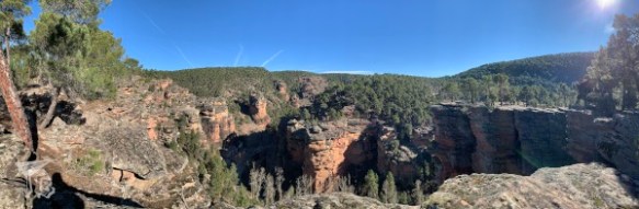 A panoramic view of the top of a ravine, with the cut-off walls dropping from sight