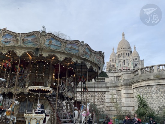 A view of the Sacre Coeur with a classical carousel in front of it