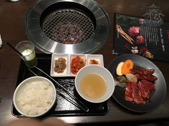 Yakiniku lunch – a dish of uncooked meat, the grill to cook it, rice, broth, and pickled vegetables