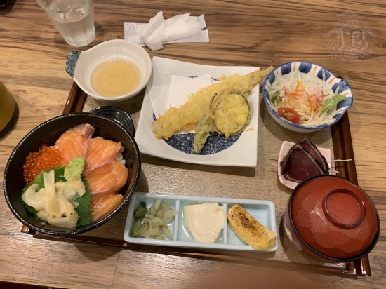Japanese dinner with fried fish, salad, miso soup and a bowl of raw fish on rice.