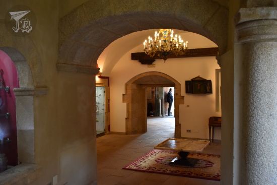 Inside a Renaissance palace, with a low arch, a glass lamp and a red carpet that try to look eclectic and end up looking bizarre