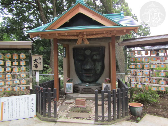 A giant Buddha face made of metal in a ceremonial pagoda