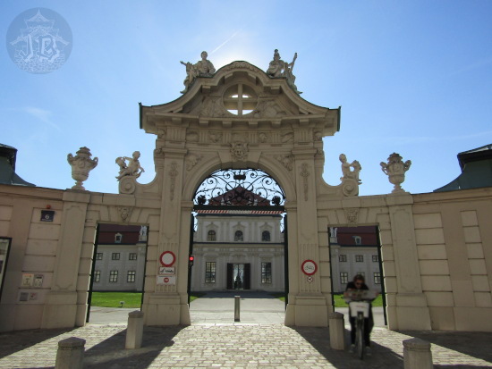 The Baroque entrance to the lower Belvedere palace, a stone gate with sculptures on top. It looks like it wants to stare you down. The palace peers through the three open doors in the background