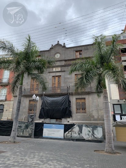 A grey building with construction work being done on it