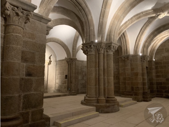 Romanesque arches and columns built in stone, and a cast ceiling.