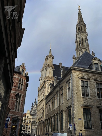 Rainbow peering through buildings at the end of the street in Brussels