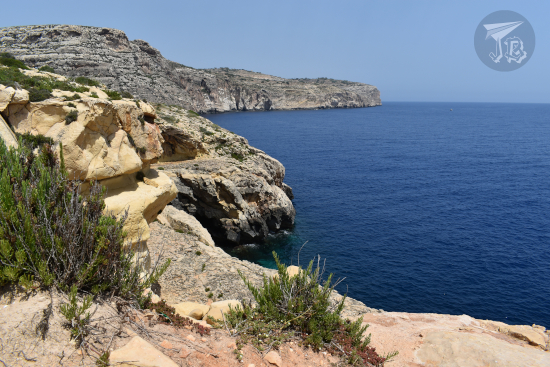 Qrendi cliffs, made if whiteish - grey rock, over a calm dark-blue ocean