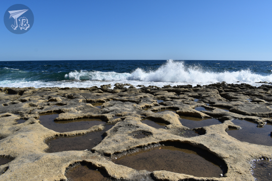 Limestone beach with waves breaking against it