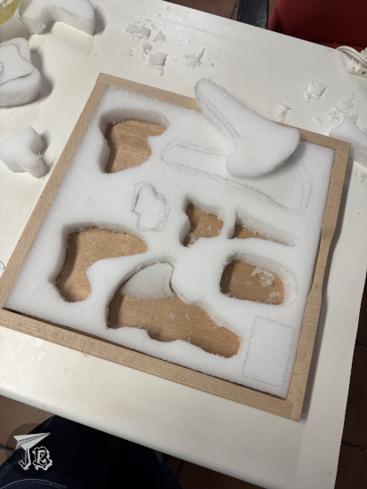 A tray with cuts to fit the different fossil bones that we cannot show for scientific reasons, so it just looks like we cut a bunch of holes with weird shapes