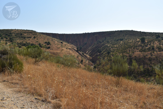 A landscape of reddish gullies in the far background