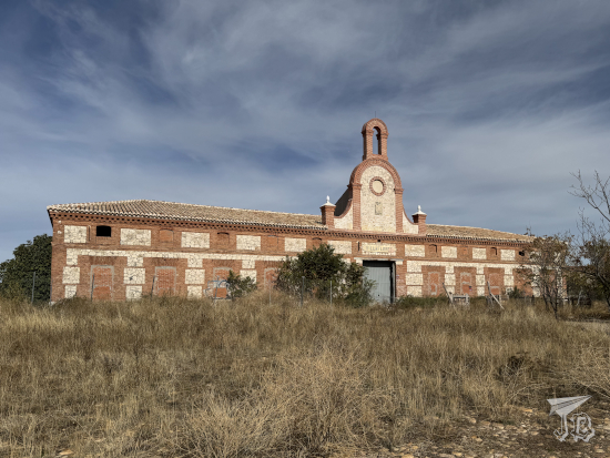 Farming house in brick and mortar, with a belltower at the centre.