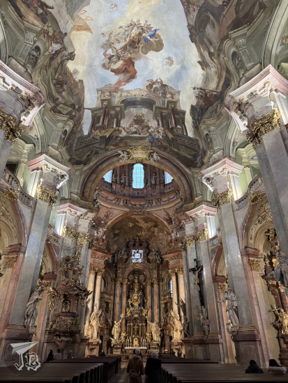 Baroque interior of St Nicholas Malá Strana church, with frescoes on the ceiling.