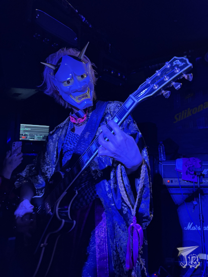 Rock guitarist wearing cheap traditional Japanese clothes and a demon mask