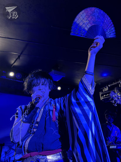 Rock vocalist wearing cheap traditional Japanese clothes, and holding a fan