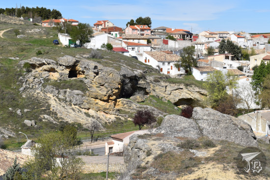 Prehistoric caves and a village in the background