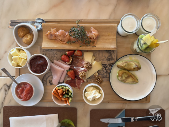 Brunch goodies: pellets, butter, jam, tomato, crudités, cheese cream, avocado, fruit, yoghurt, salmon, sausages, cheese, wallnuts and strawberries