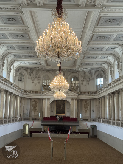 Spanish riding school: inside arena with large chandeliers hanging above
